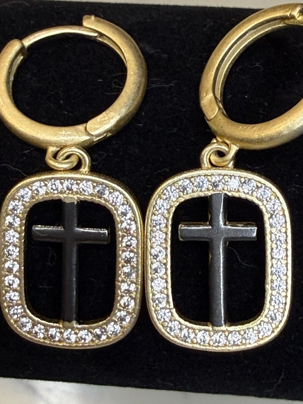 Matte gold hoop earrings with a square CZ halo around a black cross